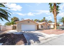 Single-story home showcasing a well-maintained yard, complemented by mature palm trees and attached two-car garage at 3145 Tarpon Dr, Las Vegas, NV 89120