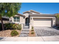 Charming single-story home featuring a two-car garage, desert landscaping, and a welcoming front entrance at 32 Via Del Fiume, Henderson, NV 89011