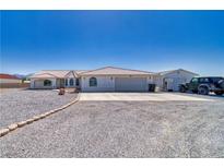 Charming single-story home features a tile roof, attached garage, desert landscaping and a long, paved driveway at 3581 Margarita Ave, Pahrump, NV 89048