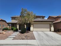Charming two-story home with a two-car garage, landscaped front yard, and concrete driveway under a clear blue sky at 5912 Kit Cove Ct, Las Vegas, NV 89131
