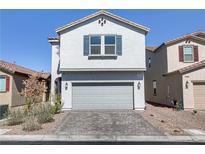 Charming two-story home with a gray stucco exterior, two car garage, and a well-maintained brick driveway at 7256 Saxby Ave, Las Vegas, NV 89113