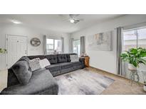 Inviting living room with tile floors, a comfortable gray sectional sofa and bright natural light from the windows at 8801 Duncan Barrel Ave # 103, Las Vegas, NV 89178