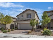 Charming two-story home with neutral stucco, tile roof, manicured landscaping, and brick paver driveway at 9917 Fletcher Peak Ave, Las Vegas, NV 89178
