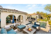 An inviting backyard oasis features a pool, spa, and outdoor seating around a cozy fire pit at 10717 Beringer Dr, Las Vegas, NV 89144