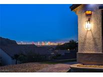 Striking Las Vegas skyline views from this home's front exterior, offering an inviting entryway and stunning surroundings at 10729 Marathon Bell Ln, Las Vegas, NV 89129