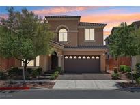Two-story home with landscaped front yard and a two-car garage against a beautiful sunset sky at 11707 Longworth Rd, Las Vegas, NV 89135