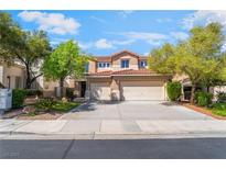 Charming two-story home featuring a red tile roof, spacious driveway, and lush landscaping at 1553 Ravanusa Dr, Henderson, NV 89052