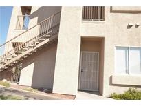 Beige two-story home featuring exterior stairwell and a secured front door with security gate at 2110 Los Feliz St # 1003, Las Vegas, NV 89156
