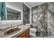 Modern bathroom featuring gray marble tile, granite countertop, and lighted mirror at 2725 S Nellis Blvd # 2052, Las Vegas, NV 89121