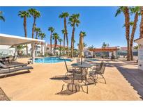 Community pool surrounded by palm trees and lounge chairs at 2725 S Nellis Blvd # 2052, Las Vegas, NV 89121