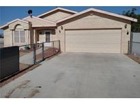 Single story home with two car garage, desert landscaping and chain link fence at 2920 Malibou Ave, Pahrump, NV 89048