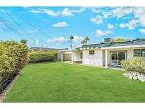 Expansive backyard featuring lush lawn, mature landscaping, and a covered patio area at 343 W Basic Rd, Henderson, NV 89015