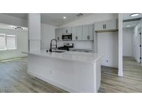 Bright kitchen boasts a large island, stainless appliances, modern cabinetry, and sleek fixtures at 4255 Breezy Point Ln, Las Vegas, NV 89115