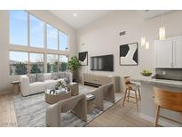 Bright living room featuring high ceilings, large windows and neutral modern decor with hardwood floors and stylish furnishings at 6056 Willow Rock St, Las Vegas, NV 89135
