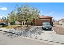 Charming single-story home with a well-maintained lawn, mature trees, and a two-car garage, situated in a friendly neighborhood at 619 Zalataia Way, North Las Vegas, NV 89031