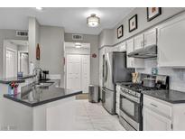 Bright kitchen features stainless steel appliances, grey countertops, and white tile flooring at 8501 W University Ave # 1083, Las Vegas, NV 89147