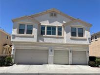 Inviting townhouse featuring a three-car garage and neutral-toned stucco exterior at 9333 Leaping Deer Pl # 103, Las Vegas, NV 89178