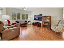 Bright living room with hardwood floors, large windows, and comfortable seating arrangement at 10532 Sea Palms Ave, Las Vegas, NV 89134