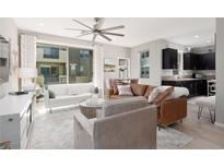Open-concept living room with a ceiling fan, modern furniture, and lots of natural light from a large window at 11256 Rainbow Peak Ave # 202, Las Vegas, NV 89135