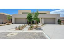 Modern home featuring a two-car garage, desert landscaping, and a clean, minimalist design with a flat roof at 1600 Pleasant Bay Ct, Henderson, NV 89011