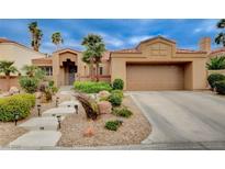 Charming single-story home featuring a well-manicured front yard with beautiful desert landscaping and a two-car garage at 2074 Sutton Way, Henderson, NV 89074
