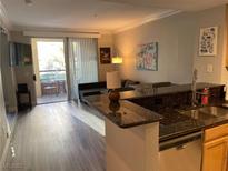 Cozy living room featuring a breakfast bar, stainless steel appliances, and outdoor patio access at 260 E Flamingo Rd # 228, Las Vegas, NV 89169