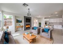 Bright open-concept living room with fireplace, modern furnishings, and easy access to the kitchen at 3065 Blue Monaco St, Las Vegas, NV 89117