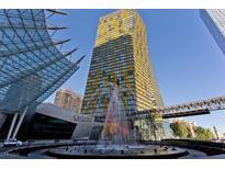 Eye-level exterior view of a yellow-striped high-rise with water fountain and glass architecture at 3726 Las Vegas Blvd # 1902, Las Vegas, NV 89158