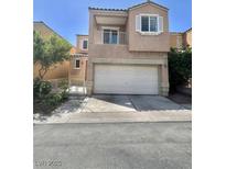 Two-story home featuring a large two-car garage, balcony, and well-kept beige stucco at 6545 Netherseal Ave, Las Vegas, NV 89139