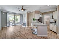 Open living space boasts hard wood flooring, a ceiling fan, fireplace, and a sliding glass door to the patio at 7173 S Durango Dr # 307, Las Vegas, NV 89113