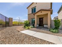 Two-story home featuring a gated front yard and a covered entryway with brick-paved accents at 7302 Sunray Point St, North Las Vegas, NV 89084