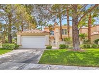 Inviting two-story home with a two-car garage, manicured lawn, and mature trees at 8411 Carmel Ridge Ct, Las Vegas, NV 89113