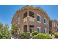 Exterior view of the building featuring a brown stucco facade, balcony, and well-maintained landscaping at 8805 Jeffreys St # 2073, Las Vegas, NV 89123