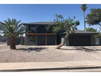 Charming two-story home with a desert landscaped yard, covered deck, and a large palm tree at 2180 Palora Ave, Las Vegas, NV 89169