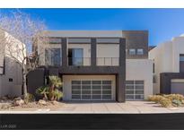 Modern two-story home featuring a two-car garage, balcony, and minimalist landscaping at 2672 Mystere Ct, Las Vegas, NV 89117