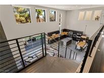 Open-concept living space with modern kitchen, dining area, and view of the pool from the second story at 2672 Mystere Ct, Las Vegas, NV 89117