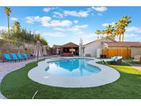 Sparkling pool with lush landscaping, covered patio, and lounge seating for outdoor enjoyment at 3099 Palmdesert Way, Las Vegas, NV 89120