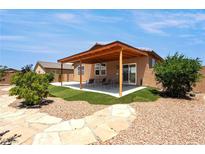 Beautiful backyard featuring a covered patio, landscaped yard, and decorative stone pathway at 3543 E Malheur Ave, Pahrump, NV 89061