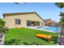 Stunning backyard features a pool, spa, artificial turf, and a patio with outdoor furniture for relaxing and entertaining at 5321 Brayden Ct, Las Vegas, NV 89131