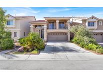 Two-story home featuring a front-facing two car garage, balcony, and well maintained landscaping at 6726 Glissando Ct, Las Vegas, NV 89139
