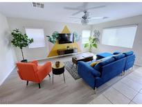 Stylish living room featuring a modern blue sofa, orange chair, and decorative accent wall at 7319 Burnt Umber St, Las Vegas, NV 89139