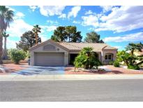 Charming single-story home featuring a two-car garage and desert landscaping with palms at 8720 Prairie Hill Dr, Las Vegas, NV 89134
