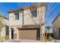 Two-story stucco home with a brown garage door and stone accents and manicured landscaping at 10316 Apefly St, Las Vegas, NV 89141