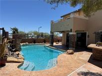 Beautiful pool area with a rock waterfall feature and steps leading into the refreshing water at 10601 Turquoise Valley Dr, Las Vegas, NV 89144
