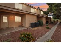 Charming two-story townhome with tan exterior, landscaped yard and private entrance at 2123 Sleepy Ct, Las Vegas, NV 89106