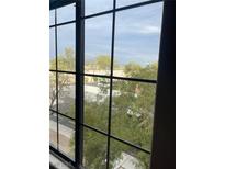 A view from a window overlooking a community street and mature trees at 2151 Hussium Hills St # 207, Las Vegas, NV 89108