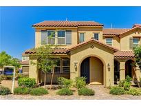Inviting two-story townhome with a tile roof, archway entry and desert landscaping at 2456 Bagnara Pl, Henderson, NV 89044