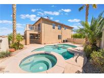 Inviting backyard pool and spa surrounded by lush landscaping, ideal for relaxation and outdoor enjoyment at 395 Suzanne Peak Ct, Henderson, NV 89012