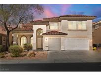 Elegant two-story home with a red tile roof, arched entryway, and a spacious two-car garage at 4607 El Camino Cabos Dr, Las Vegas, NV 89147