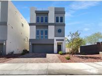 Beautiful, modern three-story home featuring a well-manicured front yard and gray color scheme at 7791 Misty Oaks Ave, Las Vegas, NV 89113